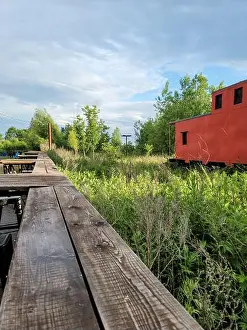 Rundown Prints: Old vintage abandoned train red caboose in a field