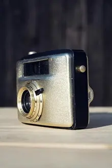 Illustrative Editorial Prints: Old vintage golden Penti I camera on wooden background
