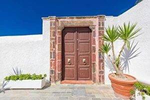 Images Dated 9th October 2019: Old wooden door with white architecture in Santorini Greece. Sunny summer weather, vacation