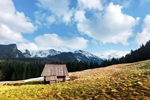 Old wooden hut and cloudy sky in spring High Tatras mountains in Kalatowki meadow, Zakopane, Poland. Landscape photography