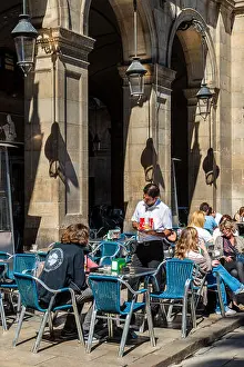 Waiter Prints: Outdoor cafe with tourists seated at tables in Placa Reial or Plaza Real
