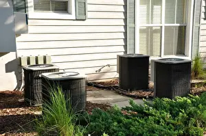 Cooling Prints: Several outdoor central air conditioning units by a building