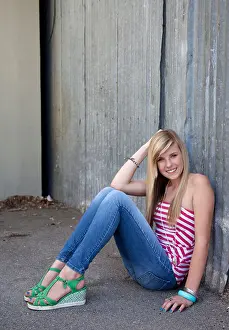 Teenage Girl Prints: Outdoor photo of pretty teenage girl sitting on the ground in grungy setting