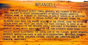 An outdoor weather-worn wooden sign explains the early history of Wrangell