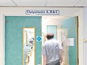Patients Prints: Outpatients clinic in a busy UK NHS hospital as doctor opens door is blurred in movement