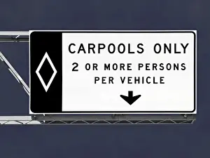 Overhead freeway carpool only sign with storm sky