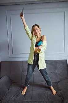 Debit Prints: Overjoyed woman showing a credit card while lifting smartphone