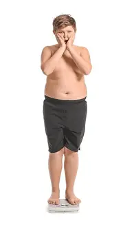 Shocked Prints: Overweight boy standing on scales against white background