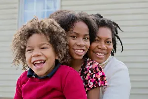 Curly Hair Prints: Pacific Islander mother and children hugging outdoors