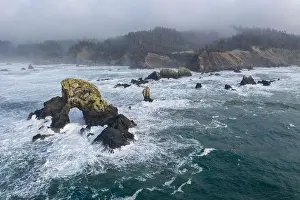 The Pacific Ocean crashes against rocks off the coast of northern Oregon. This wild region, just west of Portland, is often covered by a dark clouds