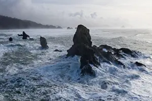 The Pacific Ocean crashes against rocks off the coast of northern Oregon. This wild region, just west of Portland, is often covered by a dark clouds