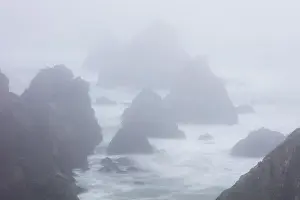 Sea Stacks Prints: The Pacific Ocean crashes against sea stacks along the foggy seashore of Northern California