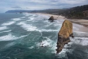 Aerial Landscape Collection: The Pacific Ocean gently washes against a massive sea stack along the Oregon's scenic shoreline
