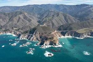 The Pacific Ocean washes onto the beautiful seashore of California, not far south of Monterey. The Pacific Coast Highway runs right along this region