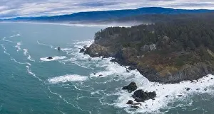 The Pacific Ocean washes against the rugged shoreline of northern California on a beautiful day. The Pacific Coast Highway runs along this area