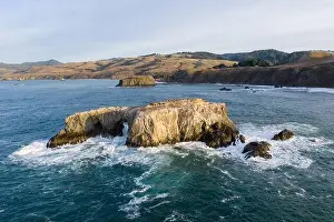 The Pacific Ocean washes against a sea stack off the northern California Sonoma coast. This region is often covered by a thick marine layer of mist