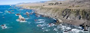 The Pacific Ocean washes against the shoreline of northern California on a beautiful day. The scenic Pacific Coast Highway runs this coastal area