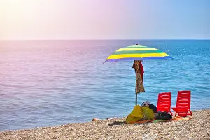 Sea Prints: Pair of sun loungers and a beach umbrella on a deserted beach; perfect vacation concept