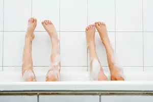 Barefooted Prints: Two pairs of feet in bathtub