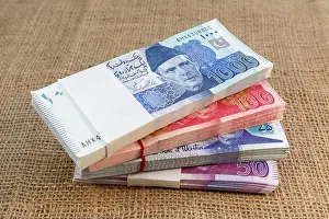 Bank Notes Prints: Pakistani currency notes bundle stacked on a burlap background with copy space