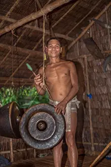 A Palaw'ano man plays a Philippine Agung gong with a beater (betay) at the tribal village in Puerto Princesa, Palawan, Philippines