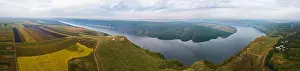 Panorama of big river canyon, village and rural fields on hills