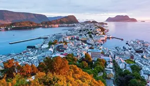 Panorama of colorful sunset in Alesund port town on western coast of Norway. Place where the ocean meet the mountains. Landscape photography