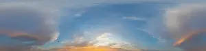 Panorama of a dark blue sunset sky with golden Cumulus clouds