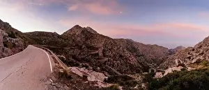 panorama sunrise landscape in the Tramuntana mountains of Mallorca with a view of the landmark snake road leading down