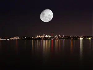 Midnight Prints: Panorama view of Sydney Harbour at night with large full moon in the night sky above CBD of Sydney NSW Australia