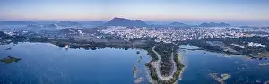 Urban Skyline Prints: Panoramic aerial drone shot at dawn dusk with road loop extending into fateh sagar lake with aravalli hills in distance