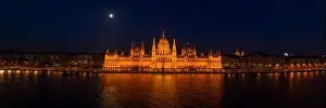 Quai Prints: Panoramic aerial drone shot of front facade of Hungarian Parliament with lights on in Budapest night