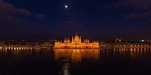 Neo Gothic Prints: Panoramic aerial drone shot of Hungarian Parliament with lights on during Budapest evening