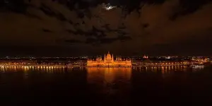 Quai Prints: Panoramic aerial drone shot of Hungarian Parliament with lights on during Budapest evening