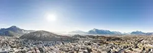 Salzach Prints: Panoramic aerial drone view of Salzburg snowy old town with view of Unesberg Kapuzinerberg mountain in winter morning
