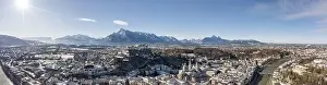 Salzach Prints: Panoramic aerial drone view of snowy Salzburg old town with river and Unesberg mountain in winter morning