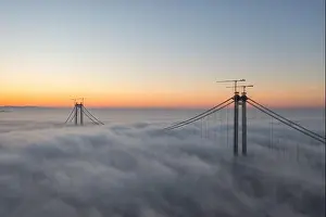 Panoramic aerial drone view from above of the suspended bridge over danube river, under construction, between Braila and Tulcea cities in Romania