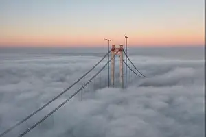 Panoramic aerial drone view from above of the suspended bridge over danube river, under construction, between Braila and Tulcea cities in Romania