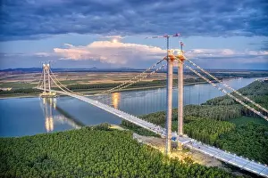 Panoramic aerial drone view from above of the suspended bridge over danube river, under construction, between Braila and Tulcea cities in Romania