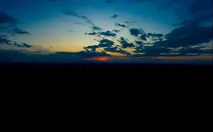 Panoramic aerial view of beautiful green tropical forest with mountains and majestic blue sky and clouds. Sunset