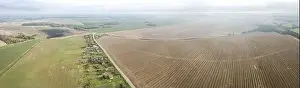 panoramic aerial view of countryside landscape with village among agricultural fields in the autumn morning mist