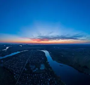 Water Country Prints: Panoramic aerial view of the nature landscape with green meadows and a river at sunset