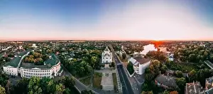 Panoramic aerial view of two old churches near river and bridge in small european city at summer day