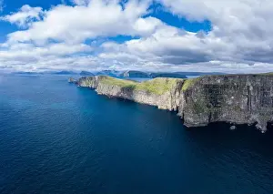 Panoramic aerial view from Sandoy island cliffs and rock stacks under the clouds, Faroe Islands