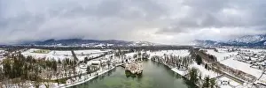 Panoramic aerial view of Schloss Anif castle moated in artificial pond at Salzburg outskirts in heavy snow during