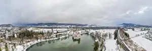 Panoramic aerial view of Schloss Anif moated castle in pond at Salzburg outskirts in heavy snow during winter with view