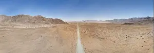 Uncertain Prints: Panoramic drone picture of lonely gravel road through the desert on the edge of the Namib-Naukluft National Park