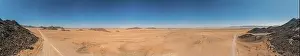 Uncertain Prints: Panoramic drone picture of lonely gravel road through the desert on the edge of the Namib-Naukluft National Park