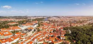 Charles Bridge Prints: Panoramic view of Prague featuring historic buildings and vibrant rooftops on a sunny day in summer