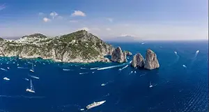 Panoramic view of south Capri Island coastline and faraglioni limestone crags in Tyrrhenian sea